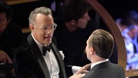Dari kursi penonton tampak Tom Hanks tengah berbincang dengan Leonardo DiCaprio. Kevin Winter/Getty Images