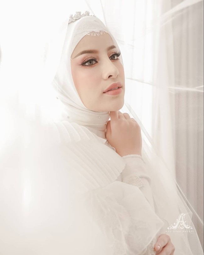 Aghnia memakai hijab bahan polycotton warna putih dengan tambahan inner lace. Wajah Aghnia yang flawless saat akad nikah hasil karya makeup artist Imel Vilentcia. Foto: instagram @byayudyahandari