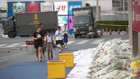 Sejumlah anak sekolah tampak membawa karangan bunga di halaman pusat perbelanjaan Terminal 21 di Korat, Nakhon Ratchasima, Thailand.