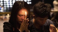 Dua orang warga tampak sedang berdoa untuk para korban tewas maupun yang terluka akibat penembakan brutal yang terjadi di Thailand pada Sabtu (8/2) lalu.