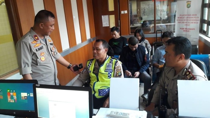 Anggota polisi, Suhartono, melaporkan insiden perampasan ponselnya oleh pelanggar lalu lintas di Polsek Kebon Jeruk
