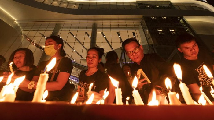 Warga menggelar doa bersama untuk para korban penembakan brutal di Thailand. Karangan bunga dan lilin juga tampak menghiasi lokasi penembakan brutal itu.