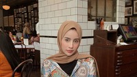 Gaya modisnya juga terlihat pada posenya yang ini. Dengan blouse cantik, Aghnia berpose sambil menggenggam segelas air di tangannya. Tampaknya ia masih menunggu pesanan makanan datang. Foto: Instagram @aghniapunjabi