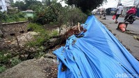 Saat ini jalan yang longsor itu ditutupi dengan terpal.