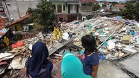 Sejumlah warga sedang menyaksikan proses pembersihan puing-puing bangunan kosan yang roboh di kawasan Mampang Prapatan, Jakarta Selatan.