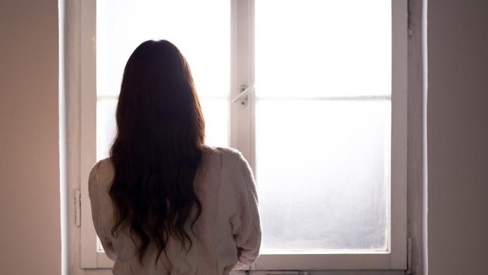 Wanita sedih Woman suffering from cancer looking through hospital window.