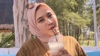 Tak hanya itu saja, posenya sambil memegang minuman kekinian ini juga tampak cantik dan menggemaskan. Ditambah dengan penampilannya yang modis. Foto: Instagram @Unamaulina