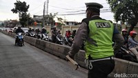 Seorang polisi menghampiri seorang pengendara motor yang menerobos jalur bus TransJakarta di kawasan Pasar Rumput,  Jalan Sultan Agung, Jakarta, Rabu (12/2/2020).