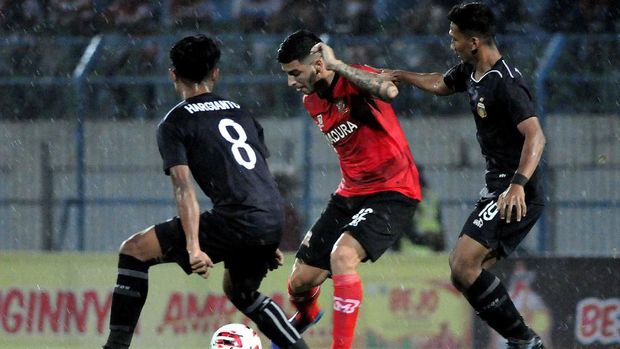 Madura United (merah) berada di posisi kedua klasemen Grup A.