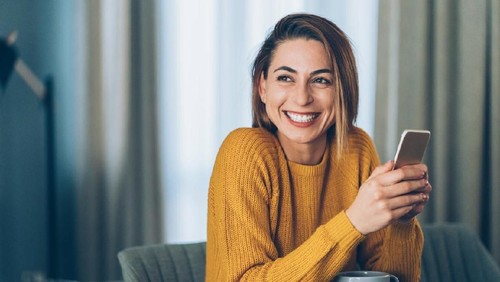 Young businesswoman using a digital tablet while standing in front of windows in office