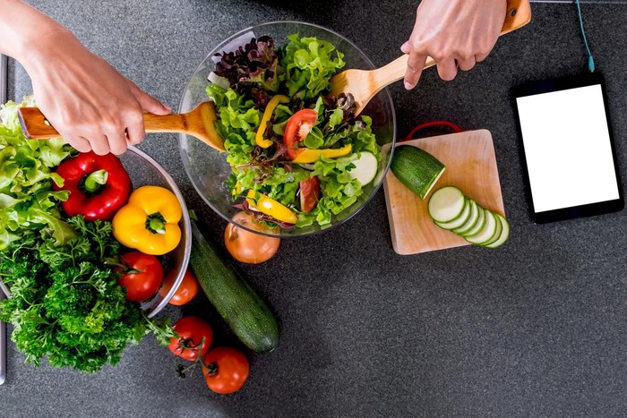 Young happiness Woman Cooking vegetables salad in the kitchen, Healthy food concept.