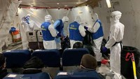 Seragam anti virus Corona pun juga dikenakan di dalam pesawat. Semua dilakukan untuk memerangi wabah virus Corona (Edward Wang/Reuters)
