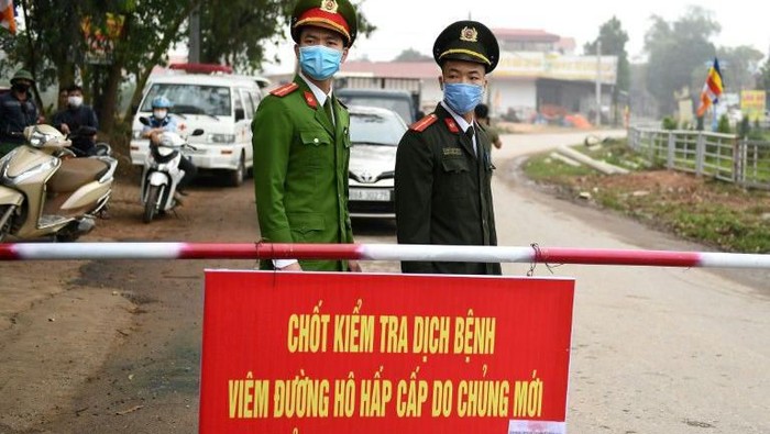 Vietnamese police stand guard at a checkpoint set up at the Son Loi commune in Vinh Phuc province amid concerns about a COVID-19 coronavirus outbreak (AFP Photo/Nhac NGUYEN)