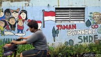 Warga lainnya melintas di depan mural bertema Indonesia di kawasan glodok yang mayoritas etnis tionghoa.
