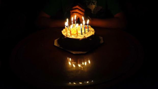 The boy is requesting blessings on his birthday by having a cake.