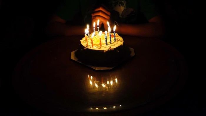 1133697331 The boy is requesting blessings on his birthday by having a cake.