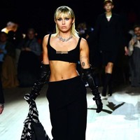 Penyanyi yang baru saja bercerai dari Liam Hemsworth itu melenggang di catwalk fashion show Marc Jacobs dengan mengenakan busana serba hitam. Dia memakai bra top dan celana panjang hitam serta sarung tangan hitam. Foto: Getty Images