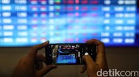 Seorang warga mengabadikan pergerakan Indeks Harga Saham Gabungan (IHSG) di BEI.