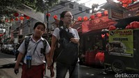 Warga berjalan di bawah hiasan lampion Imlek.