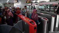 Satu per satu warga lansia dibantu oleh petugas untuk memasuki gerbang kartu elektronik untuk masuk ke kereta.