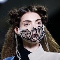 Masker transparan yang satu ini terinspirasi dari masker bedah yang banyak dipakai saat virus Corona menyebar ke seluruh dunia. Masker hitam putih ini eksis di fashion show brand Blancore, New York Fashion Week 2020. Foto: Getty Images