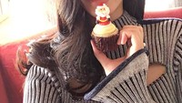 Untuk memeriahkan perayaan natal, Ming berpose dengan cupcake cokelat dilengkapi hiasan Sinterklas di atasnya. Foto: Instagram @mingxi11