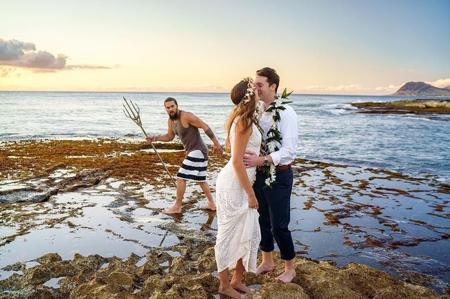 Pasangan pengantin ini mencoba membuat foto pernikahan yang sempurna di pinggir pantai. Photobomb Jason Momoa menambah kesempurnaan foto tersebut. Foto: Instagram