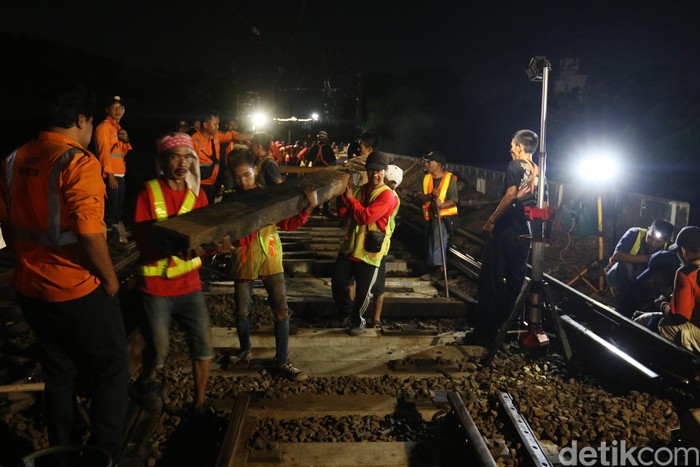 Sejumlah petugas mengangkat bantalan rel saat revitalisasi wesel rel di Stasiun KA Gambir, Jakarta, Jumat (14/2/2020) dinihari.