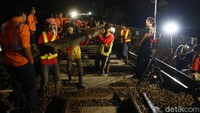 Sejumlah petugas mengangkat bantalan rel saat revitalisasi wesel rel di Stasiun KA Gambir, Jakarta, Jumat (14/2/2020) dinihari. 