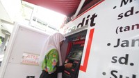 Seorang siswa menjajal dan menunjukkan kartu ATM Bank DKI pada acara OJK Goes to School di SMKN 38 Jakarta. Foto: dok. OJK