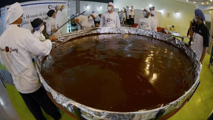 Chefs prepare chocolate while attempting to set a Guinness World Record for the largest chocolate coin in Caracas on October 1, 2015.     AFP PHOTO/JUAN BARRETO