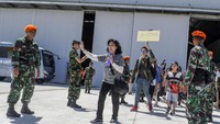 Warga Negara Indonesia (WNI) keluar dari hangar menuju pesawat yang akan mengantarkan mereka ke Lanud Halim perdanakusuma. 