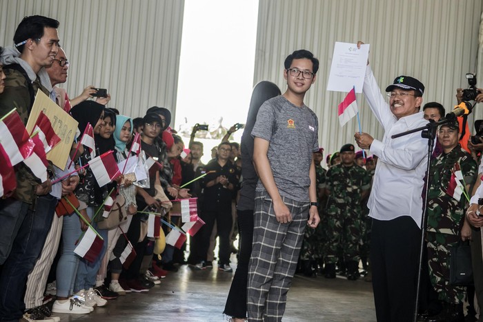WNI DARI WUHAN DI NATUNA RESMI DIPULANGKAN Sejumlah prajurit TNI bersama masyarakat mengibarkan bendera merah putih saat melepas Warga Negara Indonesia (WNI) yang telah selesai menjalani masa observasi usai dievakuasi dari Wuhan, Provinsi Hubei, China di Hanggar Pangkalan Udara TNI AU Raden Sadjad, Ranai, Natuna, Kepulauan Riau, Sabtu (15/2/2020). Pemerintah melalui Kementerian Kesehatan secara resmi telah memulangkan 238 WNI ke daerah masing-masing karena telah dinyatakan sehat. ANTARA FOTO/Muhammad Adimaja/wsj.