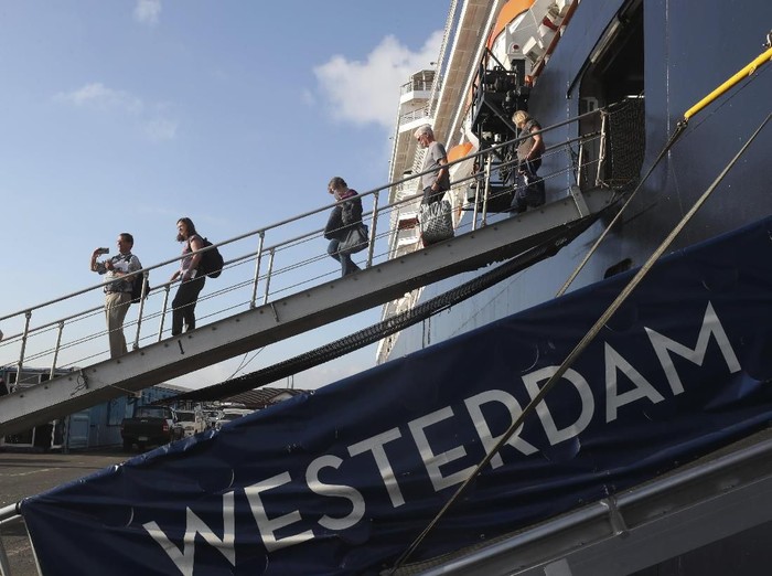 Passengers of the MS Westerdam, owned by Holland America Line disembark from the MS Westerdam, at the port of Sihanoukville, Cambodia, Saturday, Feb. 15, 2020. After being stranded at sea for two weeks because five ports refused to allow their cruise ship to dock, the passengers of the MS Westerdam were anything but sure their ordeal was finally over. (AP Photo/Heng Sinith)