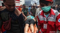 Petugas PMI mengevakuasi korban luka akibat kebakaran tersebut.