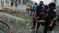 Dua orang warga membopong korban luka akibat kebakaran tersebut.