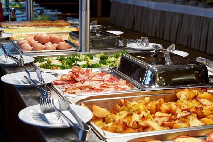 buffet dapat ularkan virus corona Family taking food in self service restaurant in hotel. A lot of domestic colorful food is served. Family with two children.