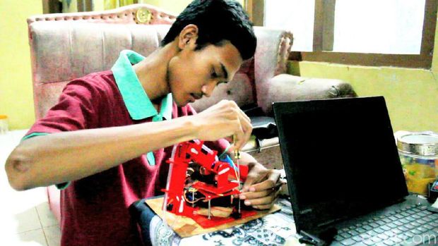Agung sedang mengotak-atik robot pembuat telur buatannya 
