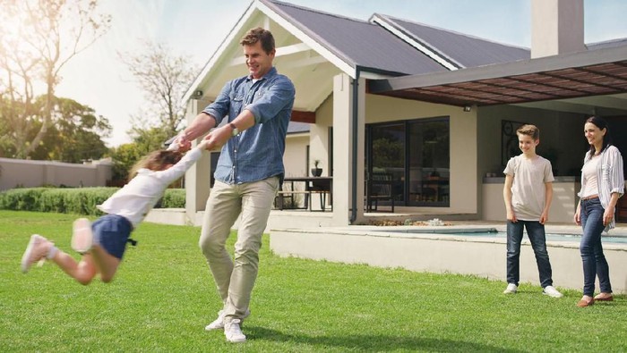 Shot of a happy young family playing together in their front yard