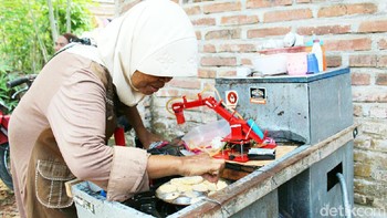 Praptining Utami (55) sudah berjualan telur dadar mini selama 1,5 tahun. Dia merasa terbantu dengan robot buatan putra bungsunya itu. (Rinto Heksantoro/detikcom)
