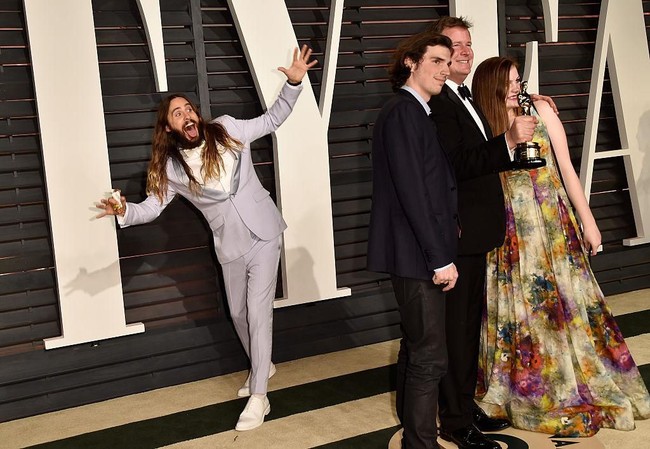 Pose konyol Jared Leto saat menginterupsi produser film James W. Skotchdopole bersama dua tamu lainnya di pesta Oscar Vanity Fair pada 2015. Foto: Pascal Le Segretain/Getty Images