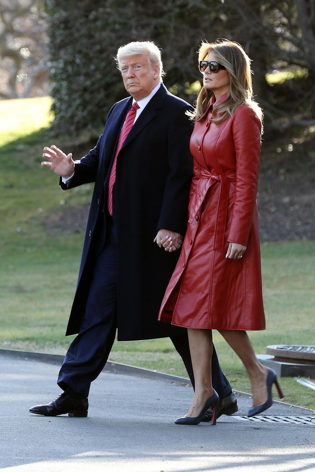 Coat merah yang dipakai Melania di RS masih jadi andalan. Namun, ia kali ini menyempurnakan gayanya dengan kacamata hitam keluaran Saint Laurent. Tampak pula kaki jenjang mantan model itu ditopang oleh sepasang heels Christian Louboutin berwarna navy. Foto: Getty Images/Tasos Katopodis