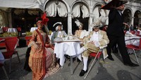 Sejumlah orang mengenakan kostum ala bangsawan Eropa di masa silam saat ikut serta memeriahkan karnaval kostum di Venesia, Italia.