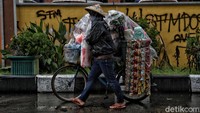 Hujan deras yang terus mengguyur tak membuat semangat para pedagang ini kendur.