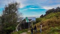 Wisatawan melihat papan informasi lokasi wisata Batu Sindu di kawasan Tanjung Senubing, Bunguran Timur, Natuna, Kepulauan Riau, Minggu (16/2/2020).