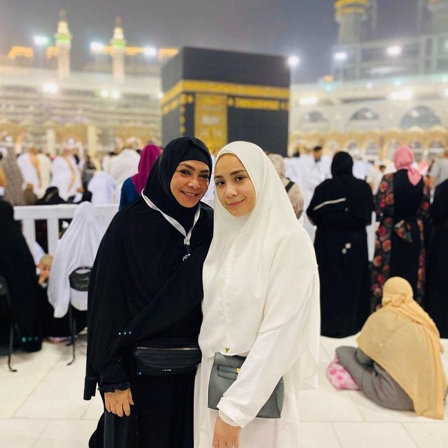 Memakai busana muslim syari, Nagita Slavina berpose bersama ibundanya, Rieta Amilia Beta setelah selesai menjalankan umrah. Keduanya mengabadikan momen bersama saat di depan Kabah. Foto: instagram @raffinagita1717