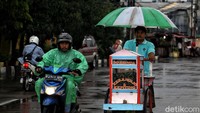 Begini potret salah satu pedagang yang rela menembus derasnya hujan demi mencari rezeki.
