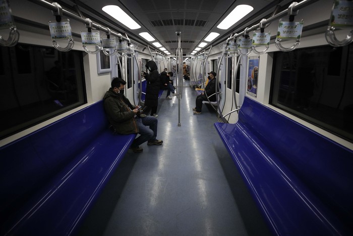 Commuters walk in a tunnel heading to a subway station during the morning rush hour in Beijing, Monday, Feb. 17, 2020. Chinese authorities on Monday reported a slight upturn in new virus cases and hundred more deaths for a total of thousands since the outbreak began two months ago. (AP Photo/Andy Wong)