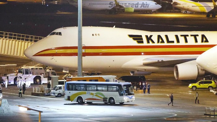 A bus carrying U.S. passengers who were aboard the quarantined cruise ship the Diamond Princess arrives at Haneda airport in Tokyo, before the passengers board a Kalitta airplane chartered by the U.S. government Monday, Feb. 17, 2020. The cruise ship was carrying nearly 3,500 passengers and crew members under quarantine. (Sadayuki Goto/Kyodo News via AP)