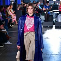 Tampil lebih kasual, Kaia Gerber mengenakan coat patent leather dipadu blouse rajut dan rok kulit. Perpaduan gaya sporty dan chic menghasilkan nuansa eklektik pada koleksi busana Coach. Foto: Slaven Vlasic/Getty Images